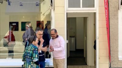 Drie mensen in gesprek voor Galerie 44 aan de Molenstraat 44 in Den Haag